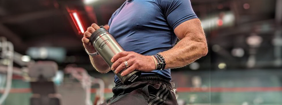 A man in the gym holding a Thermos Water Bottle