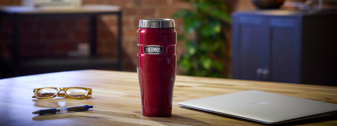 A thermos Coffee Cup on a desk in an office