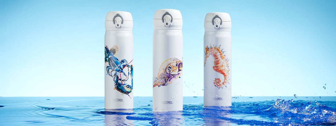 Three Thermos water bottles side by side shot in a shallow pool of water with blue sky in the background
